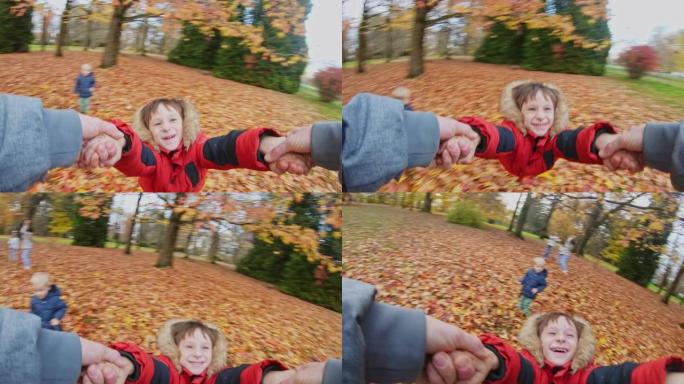 父亲在秋天公园旋转他快乐的儿子