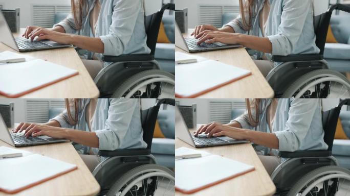 无法识别的残疾女孩使用笔记本电脑打字坐在轮椅上忙于在线工作