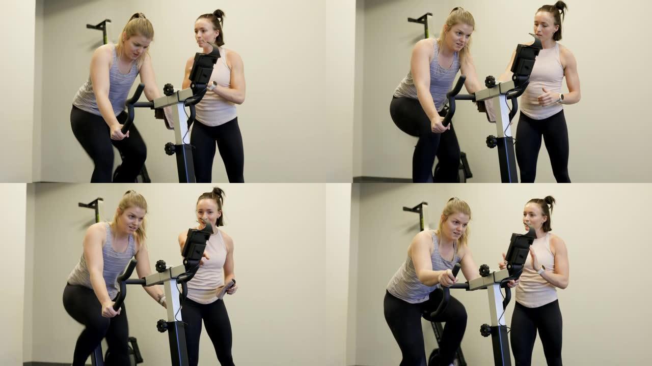 女教练激励女性在固定自行车上锻炼