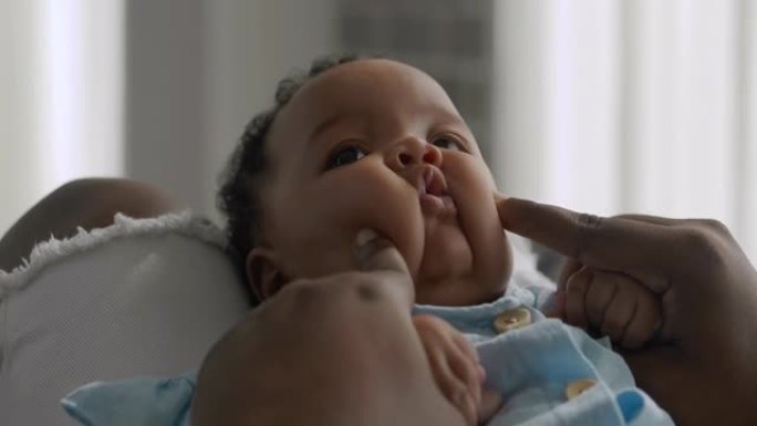非洲父亲的幸福家庭抱着婴儿儿子年龄4个月呆在家里，以防止冠状病毒或Covid-19.Family时刻
