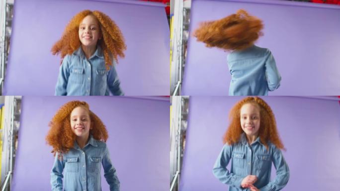 演播室拍摄的红发女孩在紫色背景下跳舞和大笑 -- 慢动作拍摄