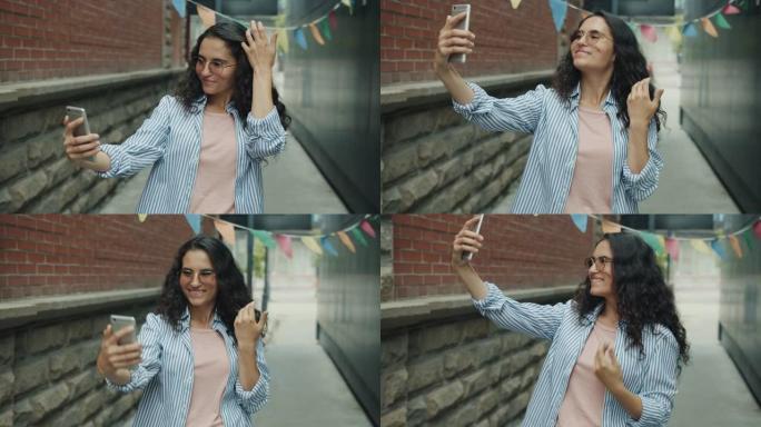 现代女学生用智能手机相机自拍的肖像在户外拍照