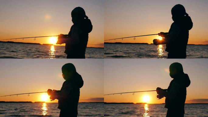 一个男孩正在日落湖附近处理钓鱼竿