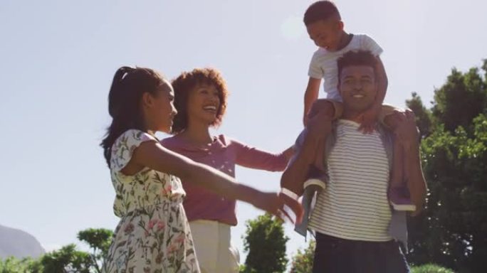 快乐的非洲裔美国父母，女儿和儿子在户外散步