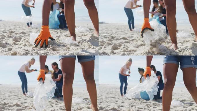 多样化的女性朋友将垃圾放在海滩上的垃圾袋中