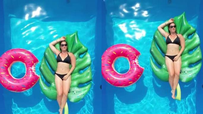 垂直: 一个阳光明媚的周末，穿着比基尼的女性在花园游泳池放松。