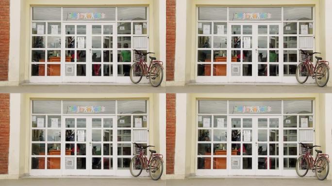 在阿根廷一所公立学校的前门骑自行车。