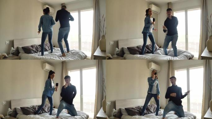 一对年轻的无忧无虑的恋爱夫妇的真实照片是在卧室的床上唱歌和跳舞的乐趣。