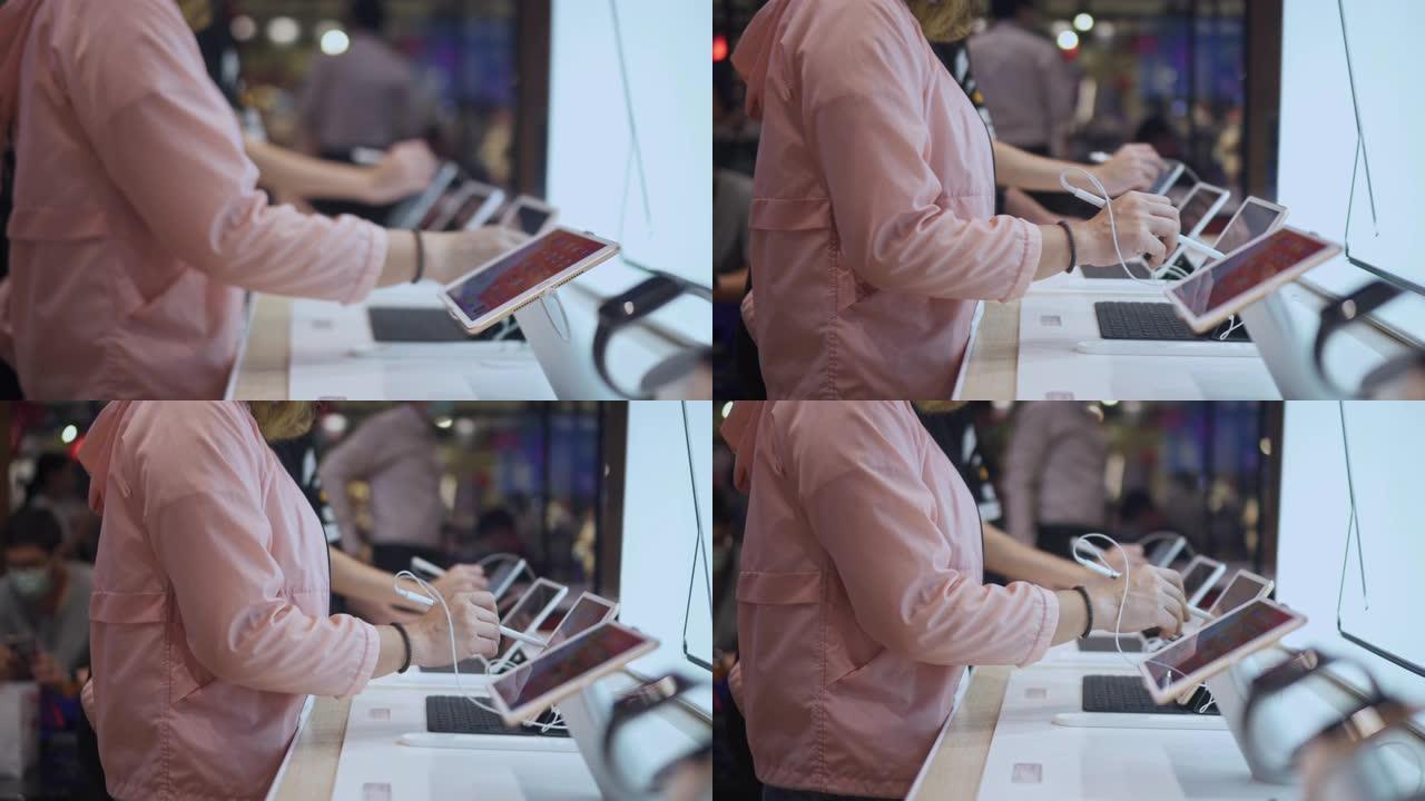 女人的手选择在电子商店购买数字平板电脑