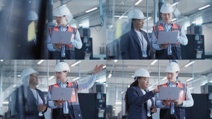 专业重工业员工在工厂戴安全帽。检查和讨论工业设施，在笔记本电脑上工作。非裔美国工程师和亚洲技术员在工
