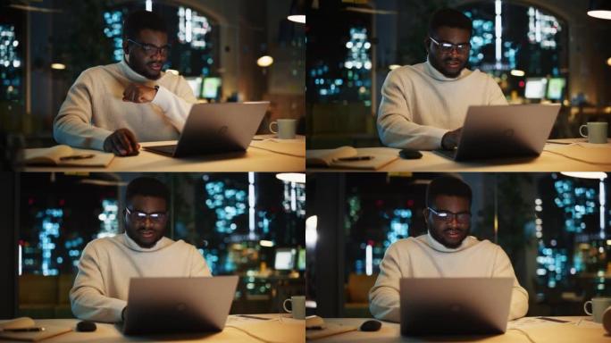 专注的项目经理坐在办公桌前，晚上在办公室的笔记本电脑上工作。非洲营销专家研究一个项目，浏览互联网和写