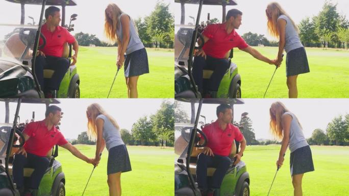 高尔夫球车中的男人在与高尔夫俱乐部练习时向女人提供建议