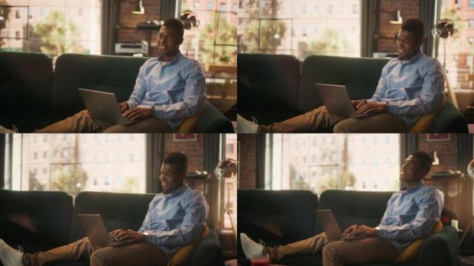 微笑的非洲裔美国男子坐在时尚舒适的客厅的沙发上，用笔记本电脑和朋友聊天。聪明的男性使用社交网络与人交