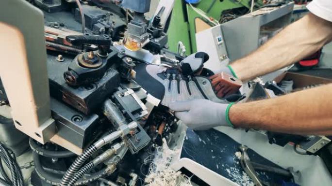 鞋类生产设施。工厂工人正在使用机器将鞋子定型