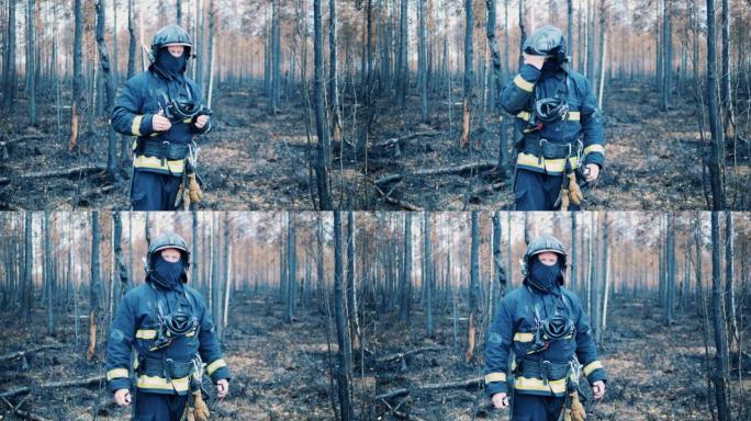 穿着安全服的消防员站在烧毁的森林中