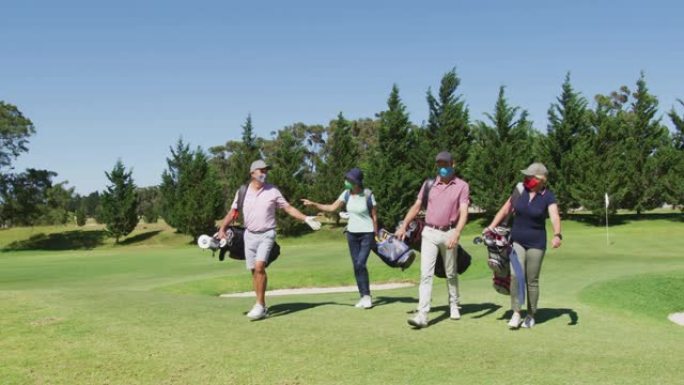 戴着口罩的老年人在高尔夫球场带着高尔夫球袋散步