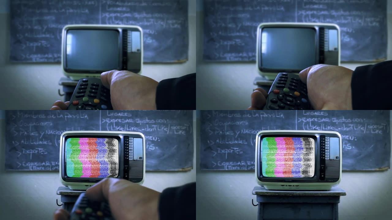 手持遥控器，在学校教室里打开带有测试模式信号的旧电视。特写。