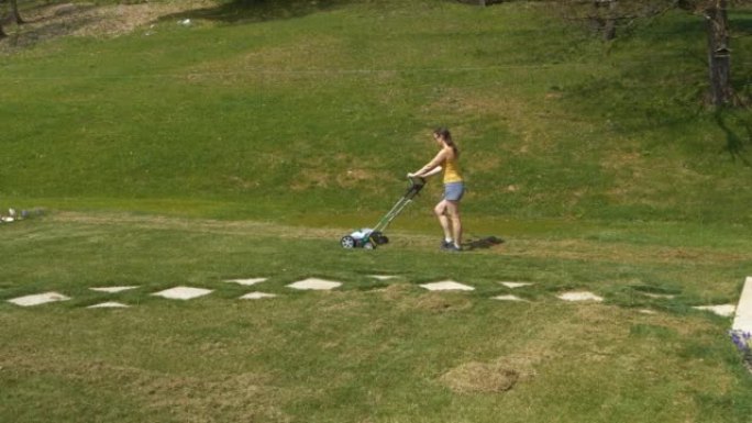 静态镜头: 年轻女性在家庭花园维护中使用草坪曝气器
