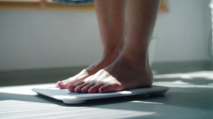 女人踩在体重秤上女人踩在体重秤上减肥