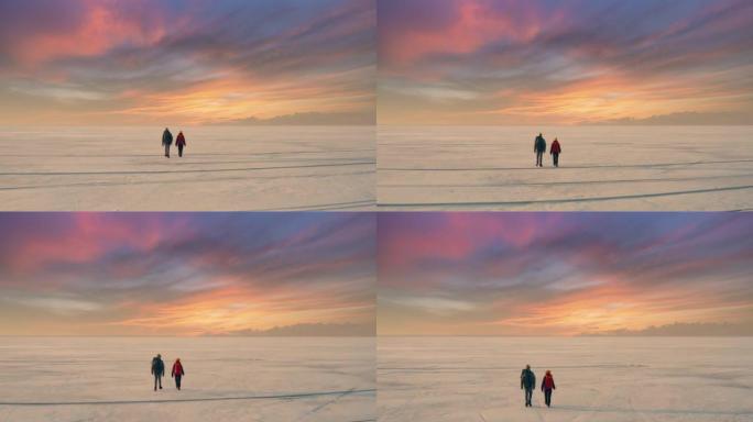 两个背着背包的游客穿过冰冷的湖面