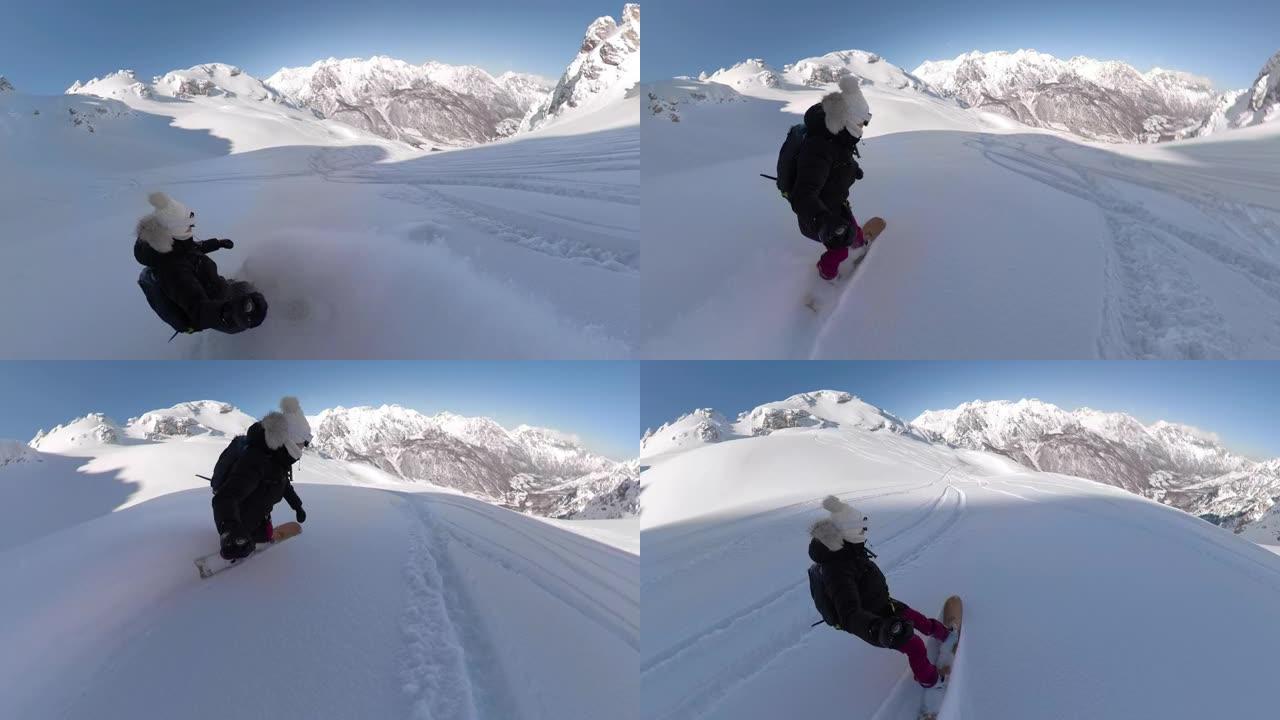 年轻的女子滑雪板骑手喜欢沿着刚被雪覆盖的山上骑行