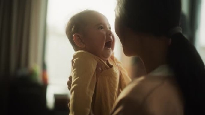 母爱的概念: 一个可爱的亚洲婴儿的肖像，笑着享受与母亲的亲密时光，用爱看着她。刚成为母亲的女人与婴儿
