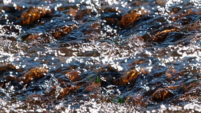 超级SLO MO特写镜头水流下一条河，水面下有棕色的石头