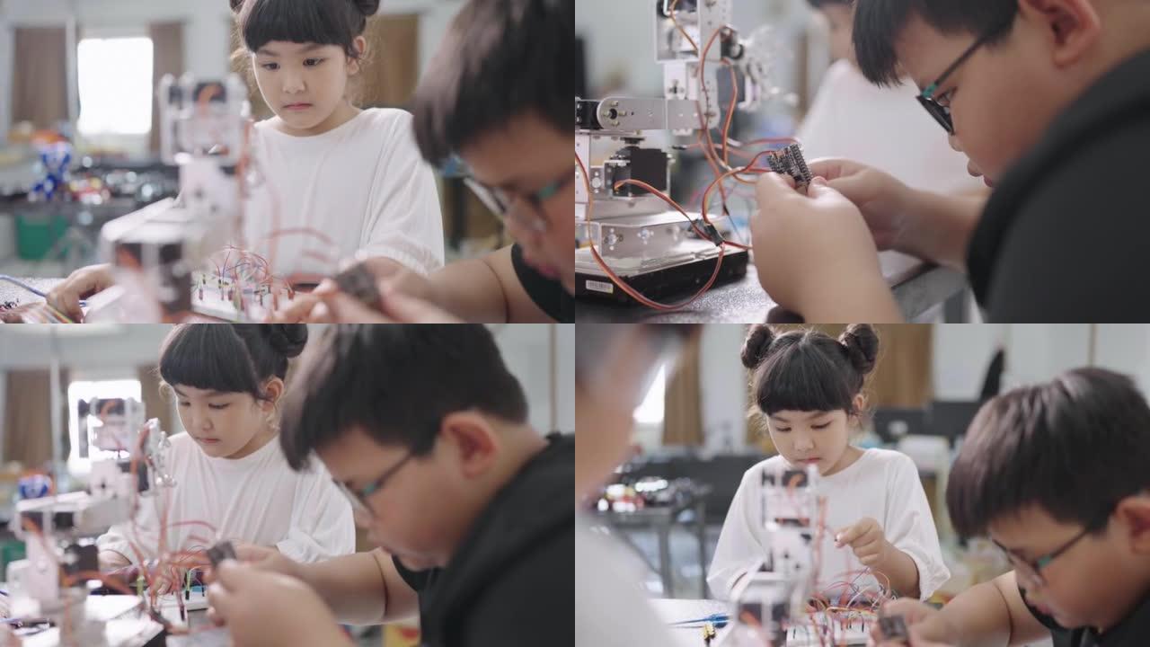 年轻的男孩和一个可爱的女孩在小学的科学课上帮助制作DIY机器人。