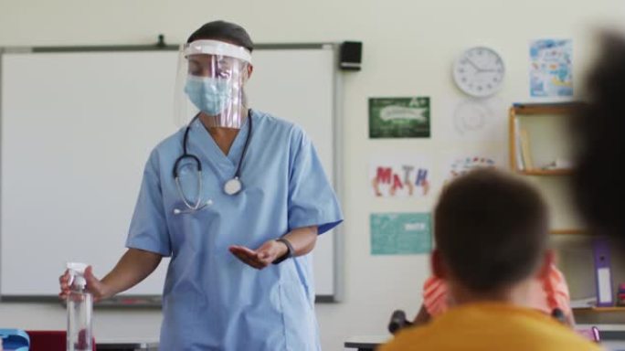 混血女医护人员戴口罩向学童展示如何消毒双手