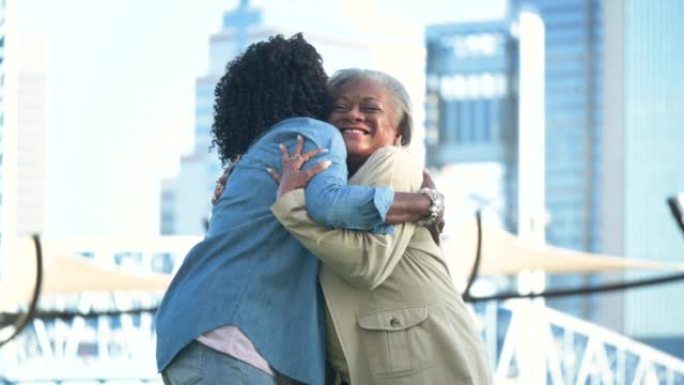 两名在城市的非裔美国高级妇女互相拥抱