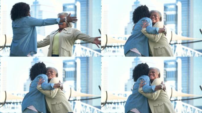 两名在城市的非裔美国高级妇女互相拥抱