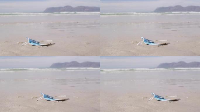 一个面具躺在沙滩上的沙滩上，背景是波浪