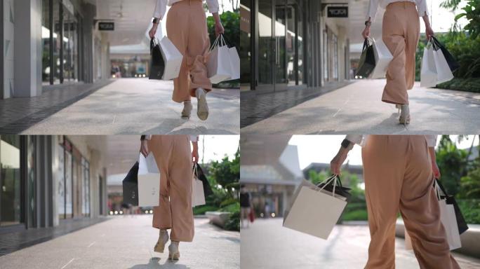 带着购物袋走路的女人的腿