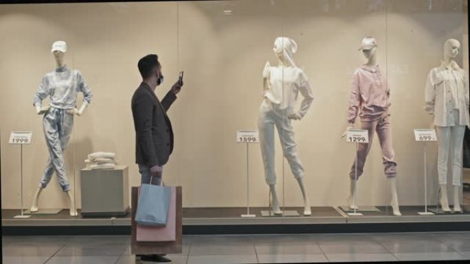 男子在购物中心为人体模型拍照