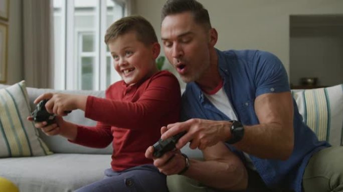 快乐的高加索父亲和儿子坐在客厅里玩电子游戏