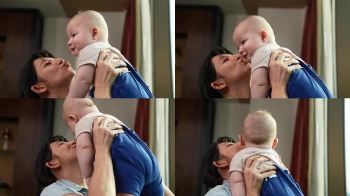 一位美丽的年轻母亲正慈爱地抱着她6个月大的婴儿。她带着爱和感情和儿子一起玩。