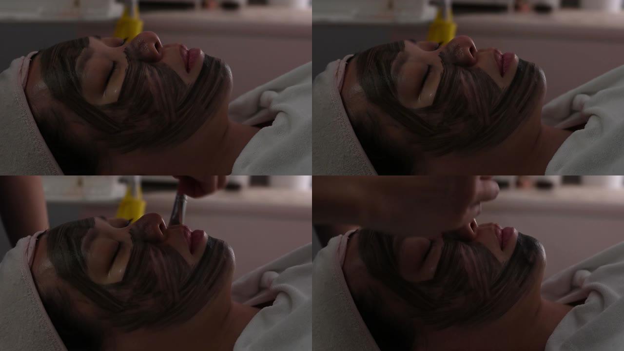 亚洲中国女性在床上躺着的面部水疗美容护理中的应用