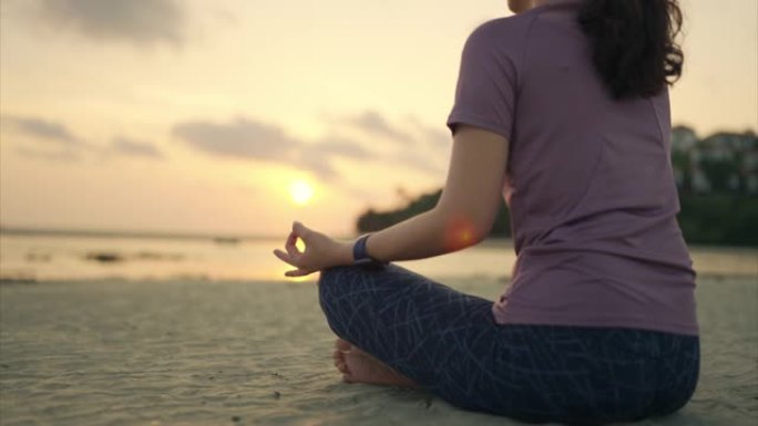 女人坐在沙滩上的莲花位置