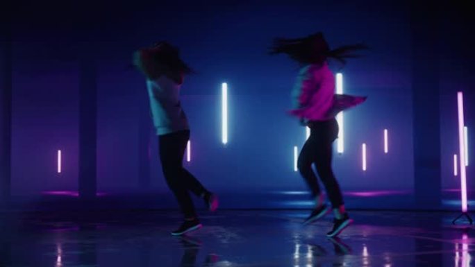 两名时尚的专业女舞者在虚拟制作工作室环境中表演嘻哈舞蹈套路，配有霓虹灯的3D地下车库空间。