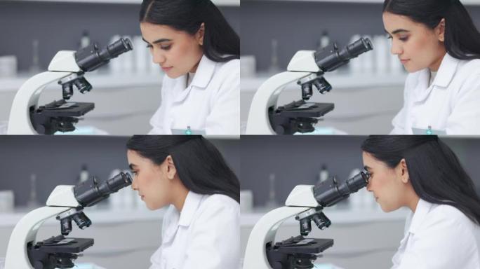 在研究实验室使用显微镜的女科学家。年轻的生物学家或生物技术研究人员使用最新的实验室技术设备工作和分析