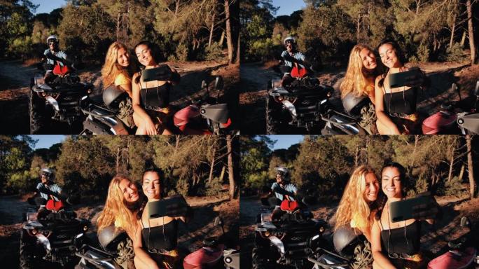 朋友微笑着在四轮摩托车冒险中使用智能手机自拍