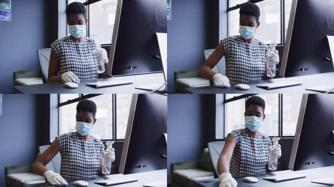 非裔美国妇女戴着口罩和手套，使她的工作站