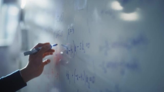 人类用蓝色记号笔在白板上绘制图表并写下数学公式。科教理念。宏跟随镜头