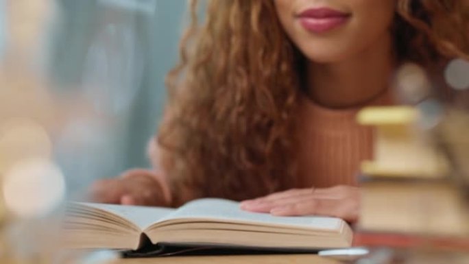 一名大学生的特写镜头用手指阅读书本上的页面，并在图书馆或家里学习期末考试。妇女准备学术学校的家庭作业