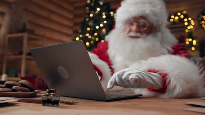 圣诞老人正在视频聊天，使用笔记本电脑并打手势