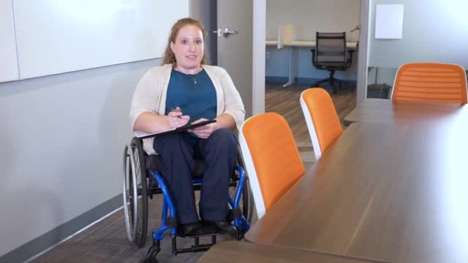 坐在轮椅上的女人在办公室会议室聊天