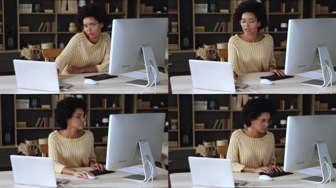 年轻的黑人女商人在笔记本电脑台式机设备之间共享文件