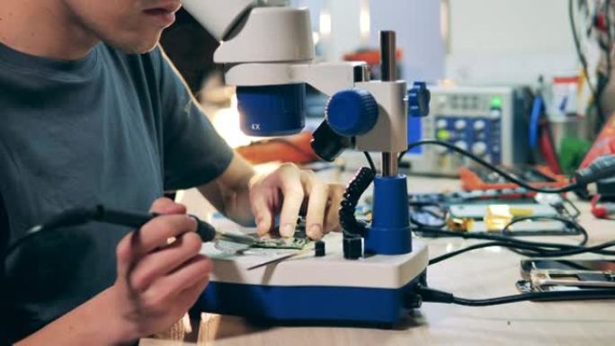 修理工在固定电路时使用显微镜