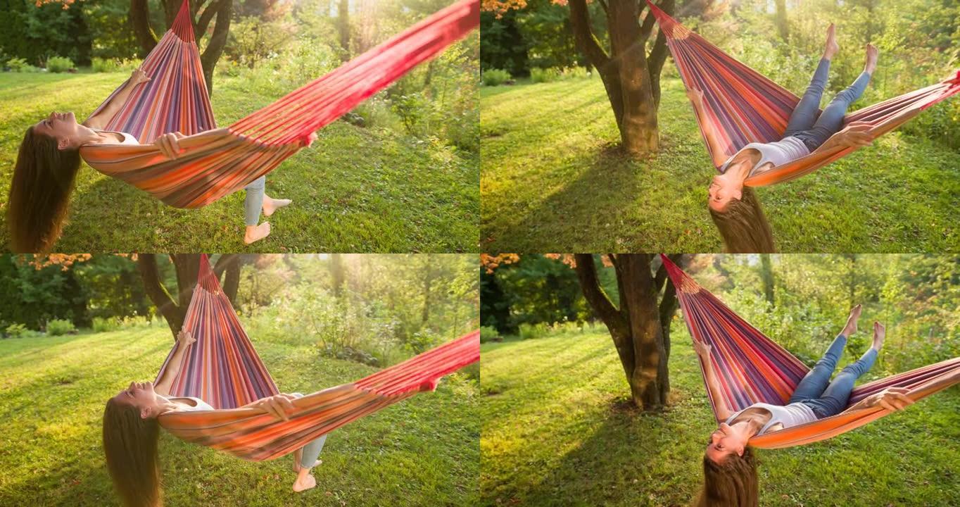 快乐的女人在暑假在后院的吊床上玩得开心