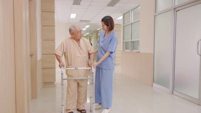 有吸引力的年轻亚洲妇女或护士在疗养院或医院走廊上照顾拐杖或助行器上的老人，感觉很有帮助和同理心。老年